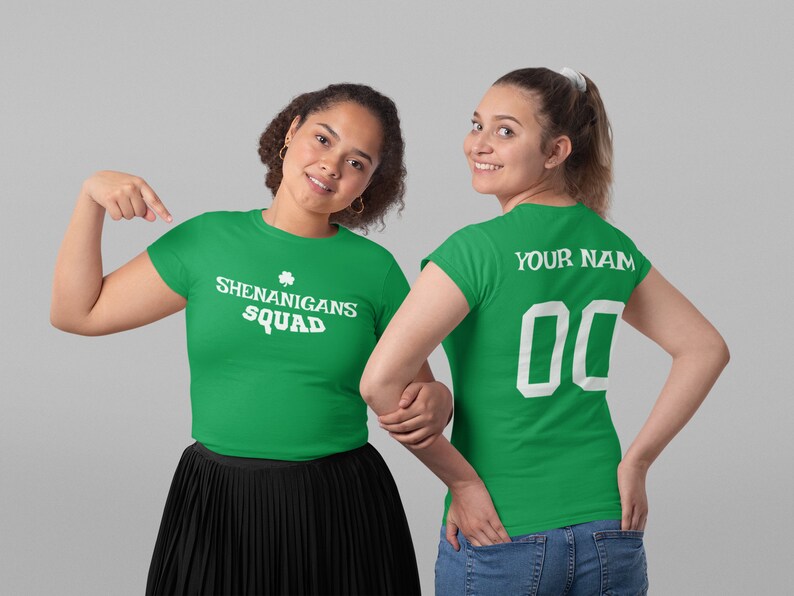 Puede incluir: Dos camisetas verdes con texto blanco. Una camiseta dice "Shenanigans Squad" con un tr&eacute;bol. La otra camiseta dice "Your Name" y tiene un n&uacute;mero blanco "00" en la espalda.
