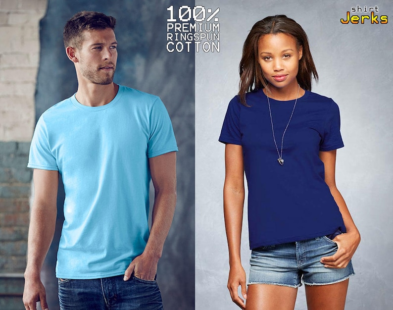 May include: A light blue crew neck t-shirt and a dark blue crew neck t-shirt. The text 100% PREMIUM RINGSPUN COTTON and the logo shirt Jerks are visible at the top. Both shirts feature short sleeves and a solid color design.
