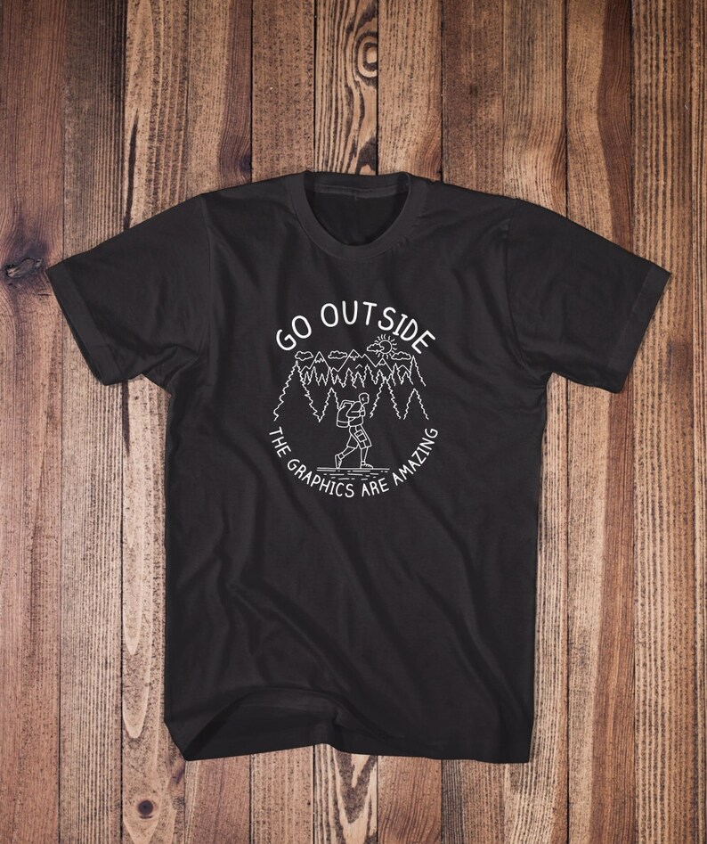 May include: Black t-shirt with a white graphic design of a person hiking in a forest with the text "GO OUTSIDE THE GRAPHICS ARE AMAZING".