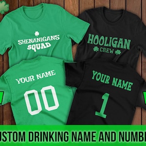 Puede incluir: Dos camisetas verdes y negras con el texto "Shenanigans Squad" y "Hooligan Crew" en la parte delantera. La parte posterior de las camisetas tiene el texto "Your Name" y un n&uacute;mero.