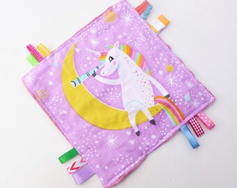 Doudou  plat carré licorne, disque hochet billes et rubans étiquettes multicolores coton et minky  rose.