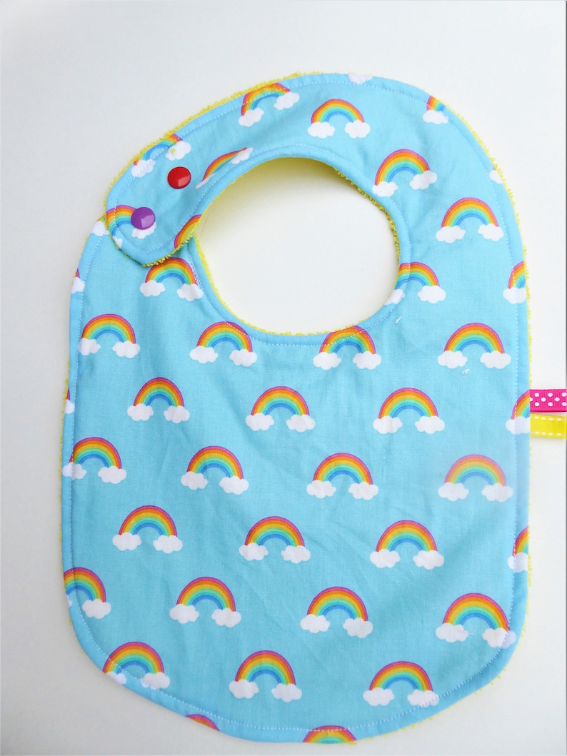 rainbow patterns and yellow sponge. Baby girlboy bib 0-12 months blue-bottomed cotton fabric