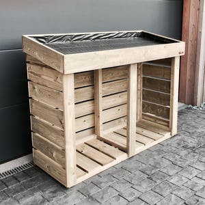May include: A wooden log storage shed with a black weatherproof cover on the top. The shed has two compartments and is made of natural wood.