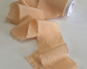 Hand dyed raw edged luxury crepe de chine silk ribbon in a shade of peach approx 5-6 cm x 3y