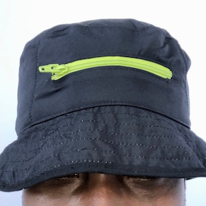 May include: A black bucket hat with a lime green zipper pocket on the front.