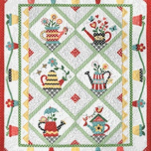 May include: A white quilt with a green and white diamond pattern. The center of the quilt features five colorful watering cans with flowers and other decorative elements. The quilt is surrounded by a red border with a white and yellow pattern.
