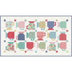 May include: A quilt with a white background and a repeating pattern of colorful teacups. The teacups are in various shades of red, pink, blue, green, and yellow. Each teacup has a different pattern.