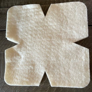May include: A white felt craft piece shaped like a star with five points. The felt is folded in half, creating a symmetrical design.