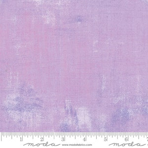 May include: A light purple fabric with a subtle textured pattern. The fabric has a slightly faded look, giving it a vintage feel.