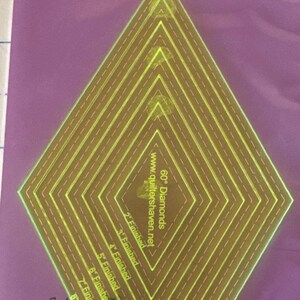 May include: A set of seven acrylic diamond templates for quilting, with finished sizes ranging from 2 to 8 inches. The templates are nested within each other, with a bright yellow design on a purple background. The text "Nesting Diamonds" is at the top.