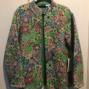 Puede incluir: Una chaqueta acolchada verde con estampado paisley y floral. La chaqueta tiene un cuello mandarín y cierre de botón.