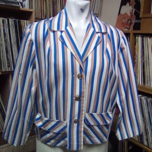 May include: A striped blue, white and pink cropped jacket with a collar and buttons.