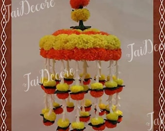 May include: A traditional Indian wedding garland made of marigold and yellow flowers. The garland is suspended from a white string and has a round base. The garland is decorated with small, round flowers.