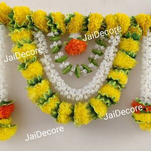 May include: A yellow and white floral garland with green accents. The garland is made of artificial flowers and is perfect for decorating for a special occasion.