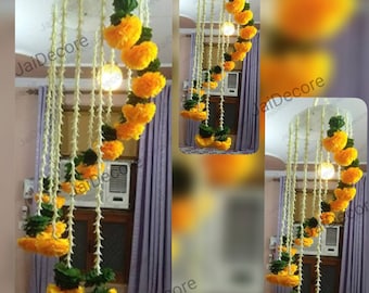 May include: A yellow and green floral garland hanging from the ceiling. The garland is made of paper flowers and is arranged in a spiral pattern.