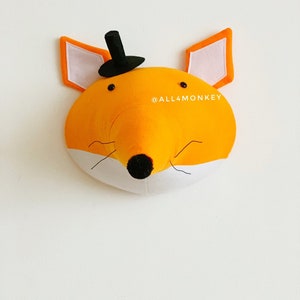 May include: A felt fox head wall hanging with a black top hat, black eyes, and a white nose and mouth. The fox is orange with white ears and a white chin. The text "@ALL4MONKEY" is visible in the lower right corner of the image.