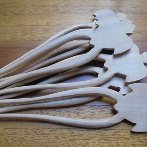 Puede incluir: Un juego de seis palitos para el pelo de madera con un dise&ntilde;o tallado decorativo en la parte superior. Los palitos son de color marr&oacute;n claro y tienen un acabado liso.