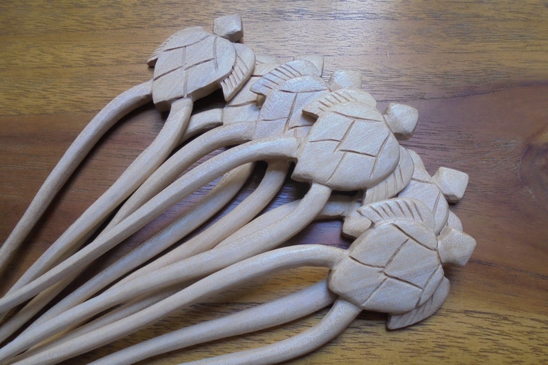 Puede incluir: Un juego de ocho palitos para el pelo de madera con dise&ntilde;os de tortugas talladas. Los palitos son de color marr&oacute;n claro y tienen un acabado liso.
