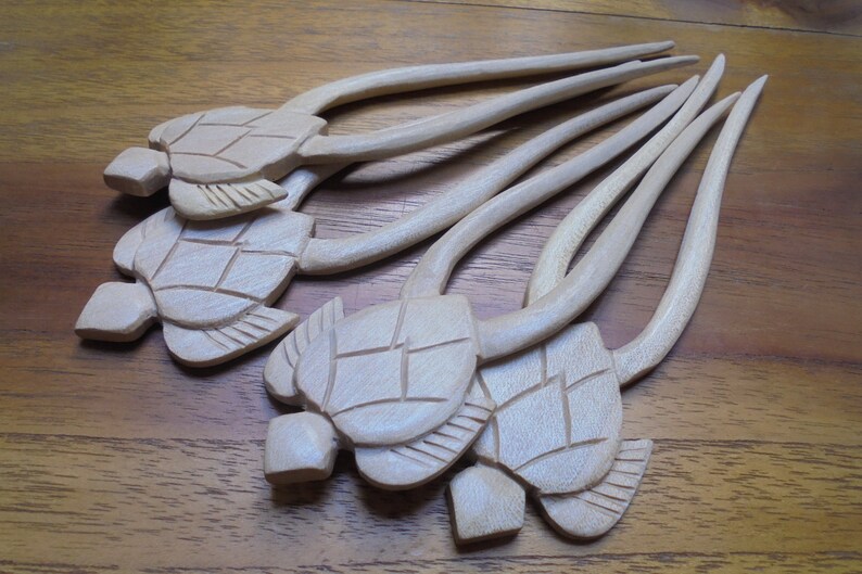 Puede incluir: Conjunto de seis palitos para el pelo de madera con tallas de cabeza de tortuga. Los palitos son de color marr&oacute;n claro y tienen un acabado liso. Las cabezas de tortuga son detalladas y tienen un color madera natural.