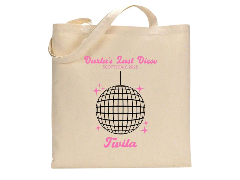 May include: A white canvas tote bag with a pink and black design. The text on the bag reads "Darla's Last Disco Scottsdale 2025" and "Twila". A black and white disco ball is in the centre of the design.