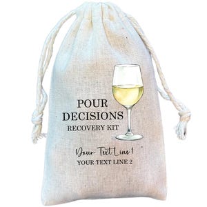 May include: A beige drawstring bag with the text "POUR DECISIONS RECOVERY KIT" and a wine glass illustration. The bag also includes space for custom text. The bag is made of a natural fabric.