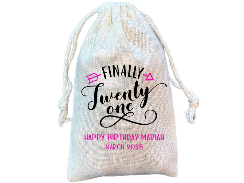 Puede incluir: Una bolsa de tela blanca con el texto "FINALLY TWENTY ONE" en letras negras y flechas rosas. El texto "HAPPY BIRTHDAY MARIAH MARCH 2025" tambi&eacute;n est&aacute; impreso en la bolsa.