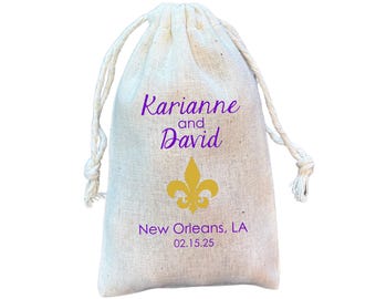 May include: A white cotton drawstring bag with purple text that reads "Karianna and David" and a gold fleur-de-lis. The bag also has the text "New Orleans, LA 02.15.25".