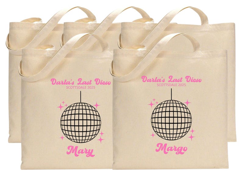 May include: Six white canvas tote bags with pink text and a black disco ball graphic. The text on the bags reads "Darla's Last Disco Scottsdale 2025" and includes the names "Mary" and "Margo".