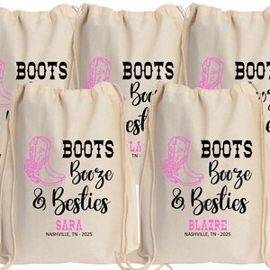 May include: A set of five off-white drawstring canvas bags featuring a pink cowboy boot graphic and the black text "BOOTS Booze & Besties". Two bags are personalized with the names "SARA" and "BLAIRE" above "NASHVILLE, TN - 2025" in pink text.