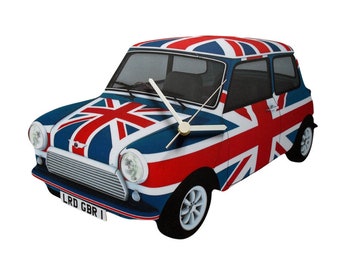 May include: A wooden clock shaped like a classic Mini Cooper car, painted with the Union Jack flag. The clock has silver hands and a gold center. The car has a license plate that reads "LRD GBR".