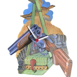 May include: A wooden wall clock with a hunting theme. The clock features a shotgun, a box of shotgun shells, and two flying grouse. The clock face is white with black numbers and hands.