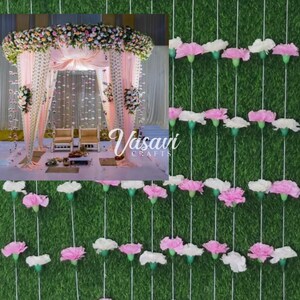 May include: A wedding mandap decorated with pink and white flowers, with a backdrop of white and pink sheer fabric. The mandap is set up in a room with a green carpet. The image also shows a close-up of a string of pink and white paper flowers hanging against a green background.