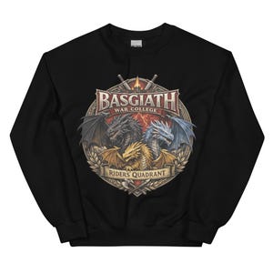 May include: Black sweatshirt featuring a detailed graphic of three dragons with different colored wings. The graphic includes the text "BASGIATH WAR COLLEGE" and "RIDERS QUADRANT" in a circular design with swords and laurel leaves.