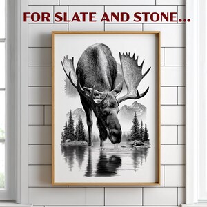 May include: Black and white framed print featuring a moose drinking from a lake, with mountains and trees in the background. The artwork is in a realistic style, with the text "FOR SLATE AND STONE..." at the top.