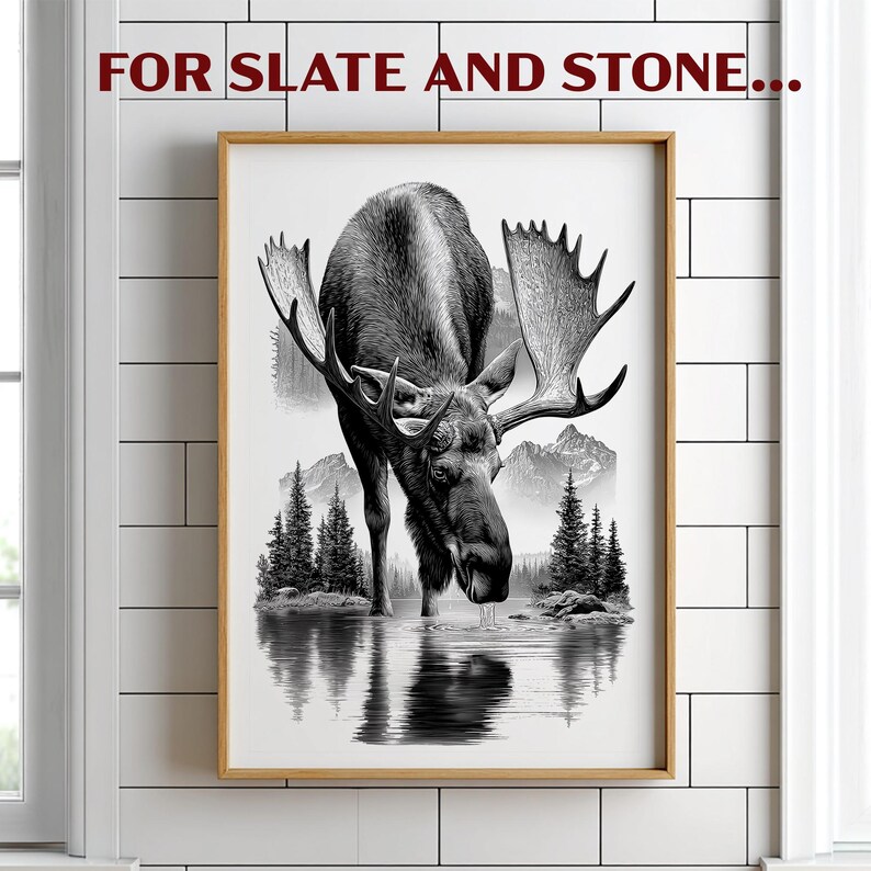 May include: Black and white framed print featuring a moose drinking from a lake, with mountains and trees in the background. The artwork is in a realistic style, with the text "FOR SLATE AND STONE..." at the top.