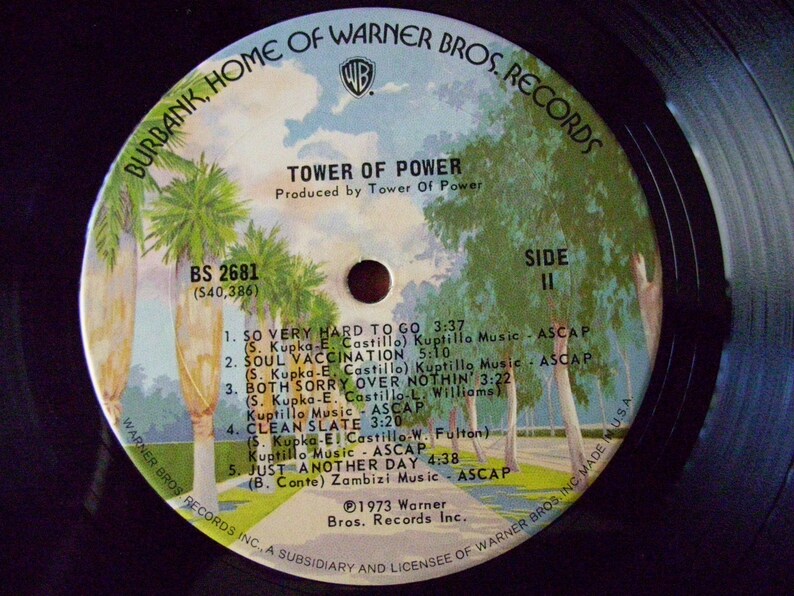 Pu&ograve; includere: Un disco in vinile nero con un'immagine colorata di palme e un cielo blu. Il disco &egrave; intitolato "Tower of Power" e presenta i titoli delle canzoni "So Very Hard to Go", "Soul Vaccination", "Both Sorry Over Nothin'", "Clean Slate", e "Just Another Day".