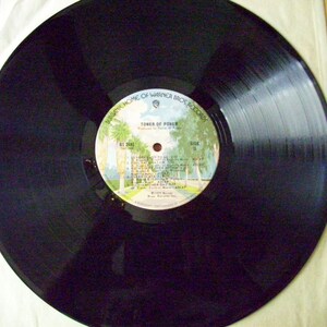 Pu&ograve; includere: Disco in vinile nero con un'etichetta bianca. L'etichetta presenta un'immagine di palme e un edificio con il testo "Tower of Power" e "Warner Bros. Records".