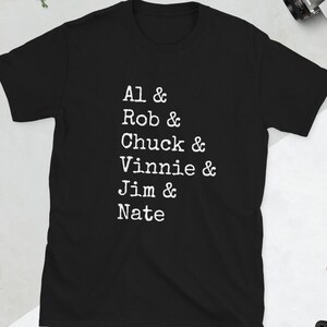 May include: Black t-shirt with white text that reads "Al & Rob & Chuck & Vinnie & Jim & Nate"