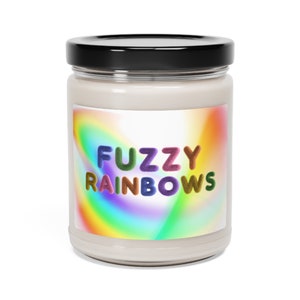 May include: A glass jar candle with a white label that says "FUZZY RAINBOWS" in colorful, fuzzy letters. The label has a rainbow swirl design.