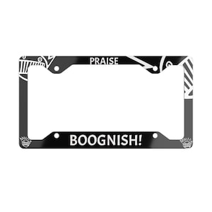 May include: Black license plate frame with white text that reads "PRAISE" at the top and "BOOGNISH!" at the bottom. The frame has decorative white patterns and designs on the corners.