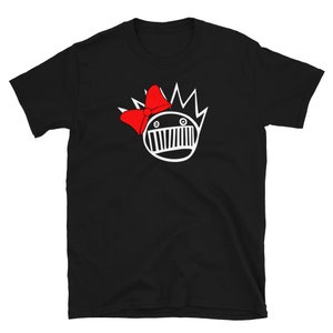 May include: Black t-shirt featuring a white graphic of a cartoon face with a red bow. The face has spiky hair and a wide mouth.