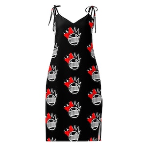 May include: A black sleeveless dress featuring a repeating white graphic pattern of a stylized face with a crown and a bright red bow. The dress has a V-neckline and thin shoulder straps that tie at the top, creating a simple, fitted silhouette.