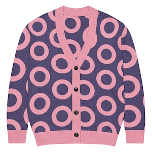 Op de afbeelding: Marineblauwe en roze cardigan met een patroon van grote roze cirkels. De kraag, manchetten en knoopsluiting zijn effen roze. De cardigan heeft zwarte knopen.