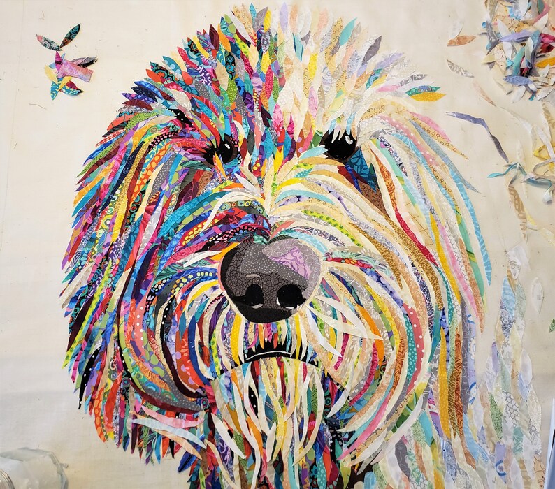 Pode incluir: Um retrato de c&atilde;o colorido em patchwork feito de retalhos de tecido. O rosto do c&atilde;o &eacute; o ponto focal, com uma variedade de cores e padr&otilde;es usados para criar a pelagem.