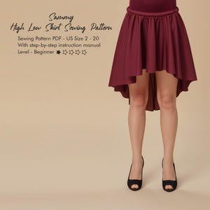 May include: A burgundy high-low skirt with a gathered waist. The skirt is part of a sewing pattern labeled "Sammy High Low Skirt Sewing Pattern". The pattern includes sizes US 2-20 and a beginner level instruction manual.