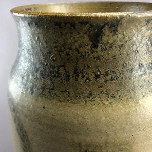 May include: A ceramic vase with a dark gray glaze on the top half and a light gray glaze on the bottom half. The glaze has a speckled appearance.