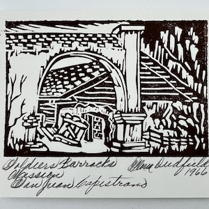 Puede incluir: Un grabado en linóleo en blanco y negro que representa los Soldiers Barracks Mission San Juan Capistrano. La obra de arte, firmada por Ellen Dudfield y fechada en 1966, presenta elementos arquitectónicos, incluyendo un arco y una columna.