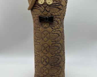 Vase en céramique représentant un chat, orné d'un nœud papillon et d'une queue frétillante, vers 1980. Hauteur : 22,2 cm ; largeur : 9,5 cm.