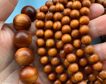 May include: A set of wooden bead bracelets in various shades of brown. The beads are round and have a smooth, polished finish. The bracelets are stacked on top of each other, creating a layered effect.