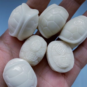 May include: Six white turtle-shaped figurines with intricate shell designs. The figurines are made of a smooth, polished material and are approximately 2 inches in length.